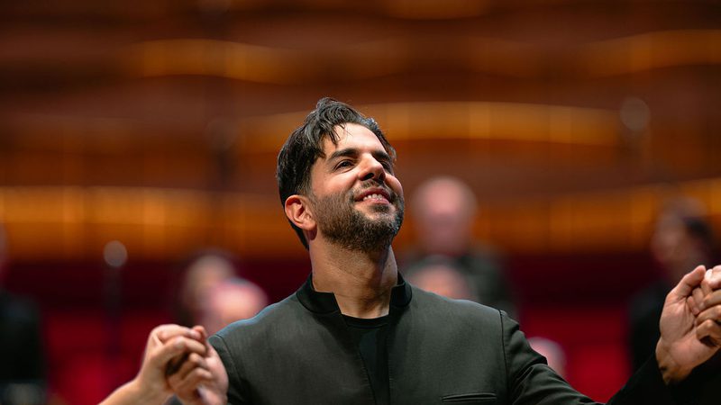 Chief Conductor Domingo Hindoyan on stage smiling at the audience