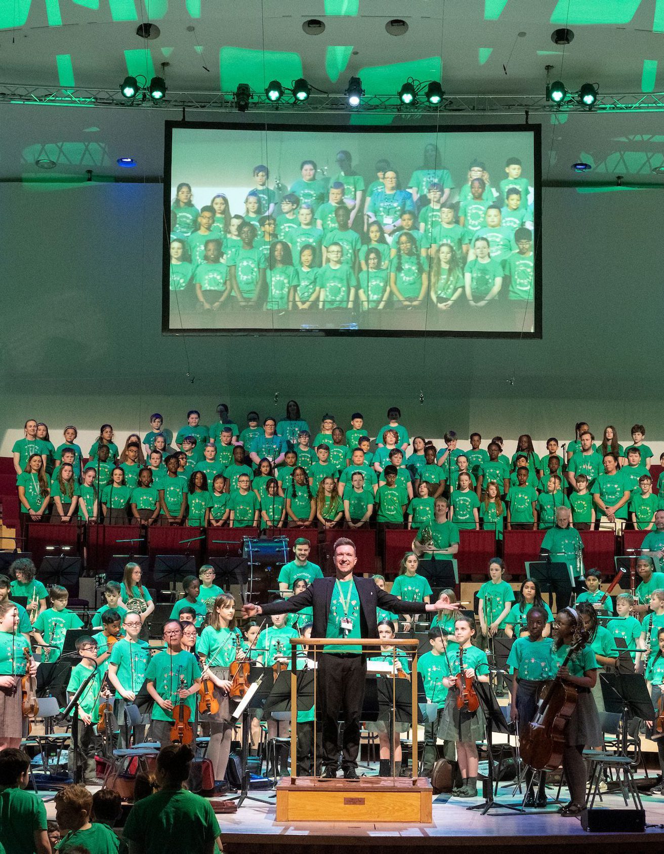 Liverpool Philharmonic Hall stage full of young In Harmony musicians all stood up and facing the audience