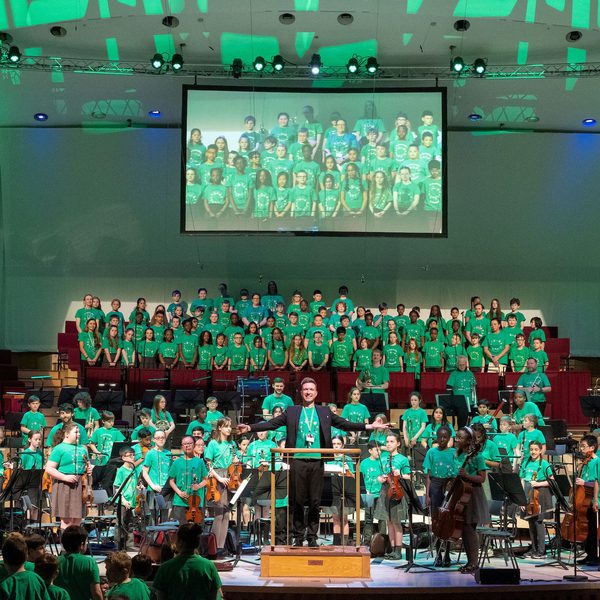 Liverpool Philharmonic Hall stage full of young In Harmony musicians all stood up and facing the audience