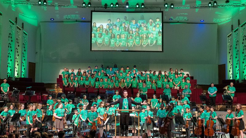 Liverpool Philharmonic Hall stage full of young In Harmony musicians all stood up and facing the audience