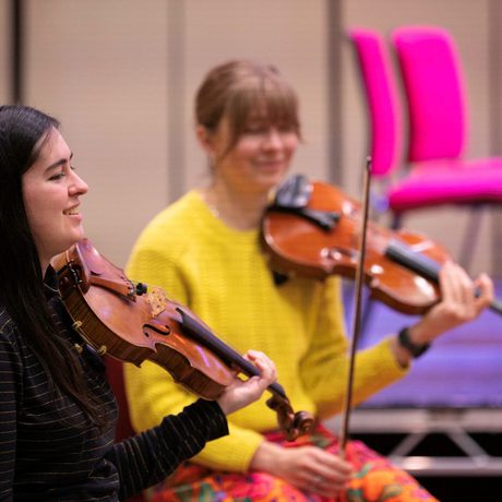 Emerging Musician and violin player Kaylee Ramella wearing a black jumper and holding her instrument in rehearsal