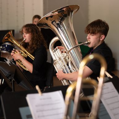 Two young musicians playing brass instruments on stage