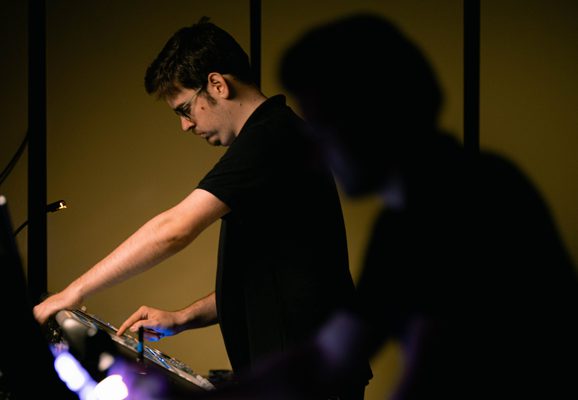 Two staff technicians working on a sound and lighting desk