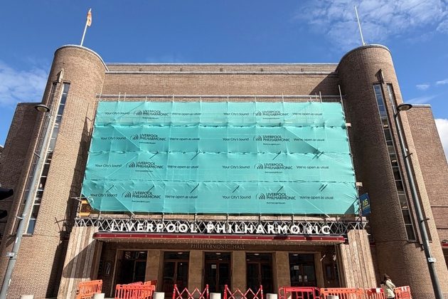 Liverpool Philharmonic Hall with scaffolding at the front, all wrapped in a teal cover