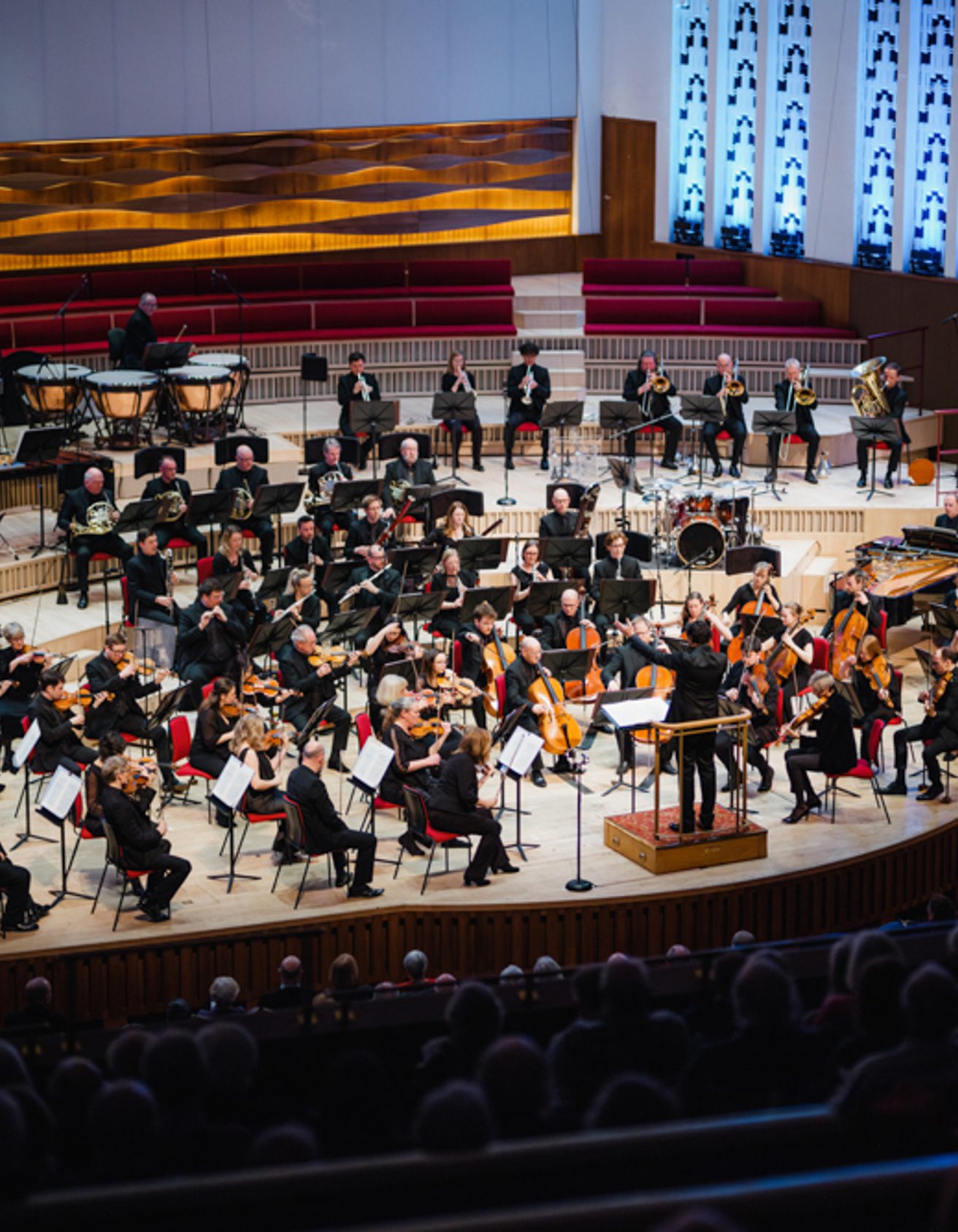 A photo of the Royal Liverpool Philharmonic Orchestra performing on stage, taken from above in the Grand Circle