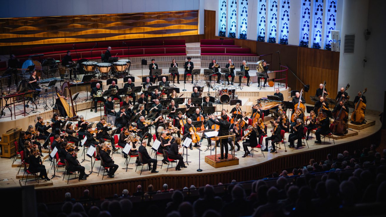 A photo of the Royal Liverpool Philharmonic Orchestra performing on stage, taken from above in the Grand Circle