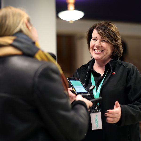 A female member of the Front Of House team greeting a member of the audience in the foyer