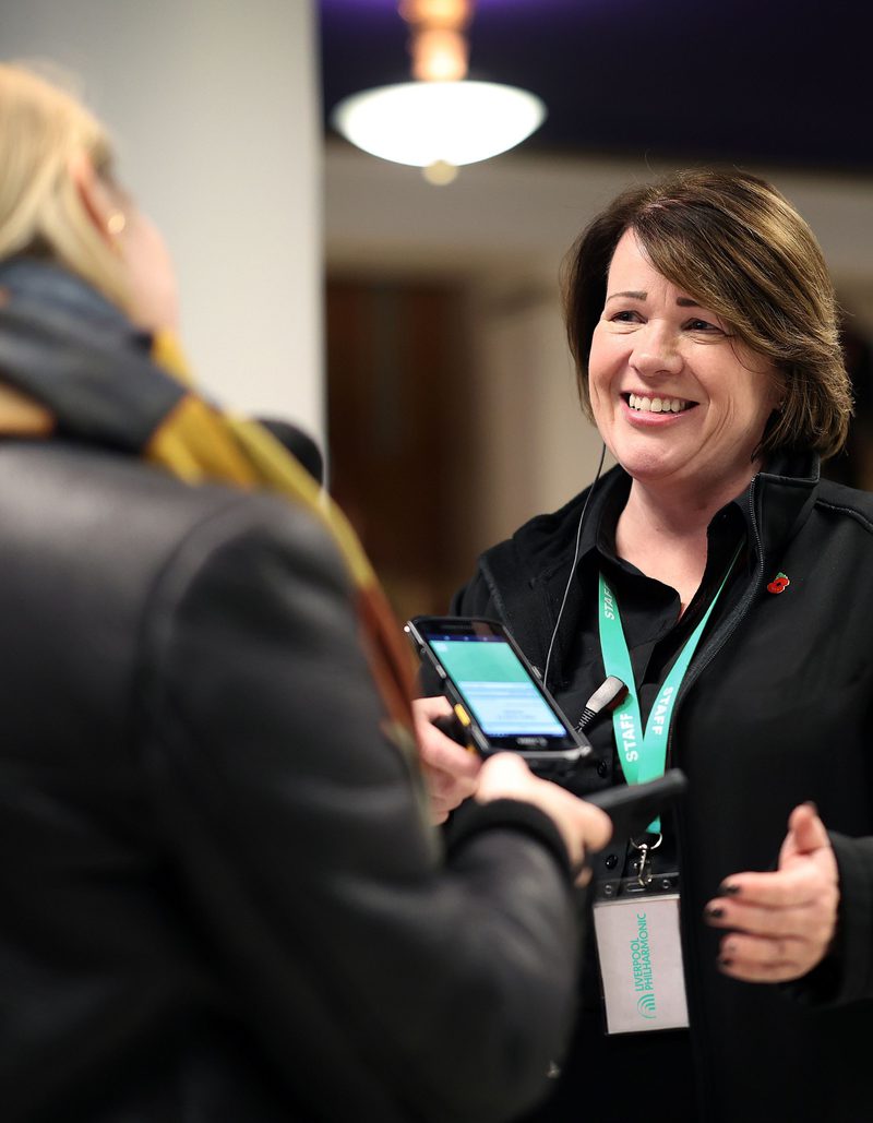 A female member of the Front Of House team greeting a member of the audience in the foyer