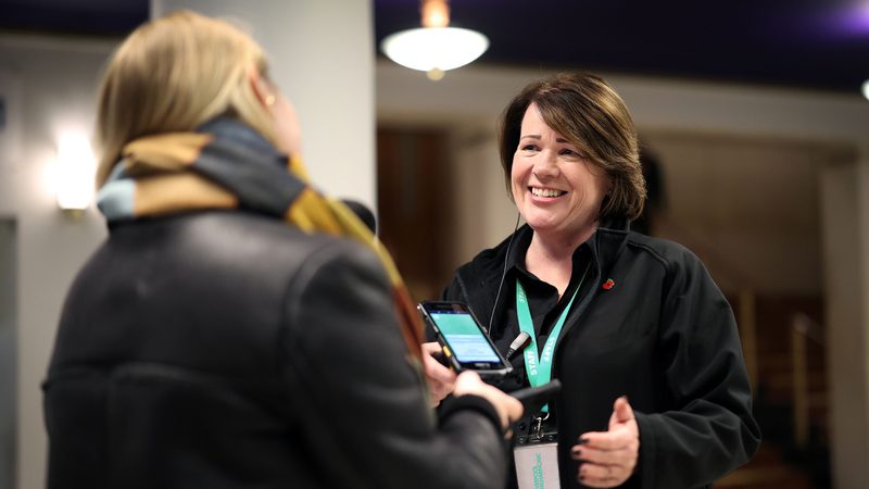 A female member of the Front Of House team greeting a member of the audience in the foyer