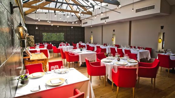 Interior of the Art School with white table linen and red dining chairs