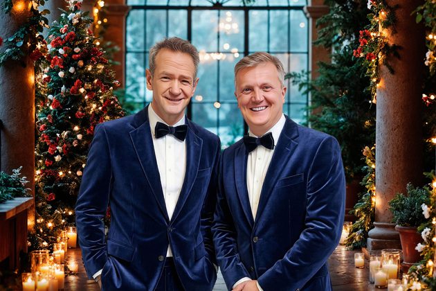 Aled Jones & Alexander Armstrong. Two white grey haired gentlemen in navy blue blazers and black bowties in a Christmas setting.