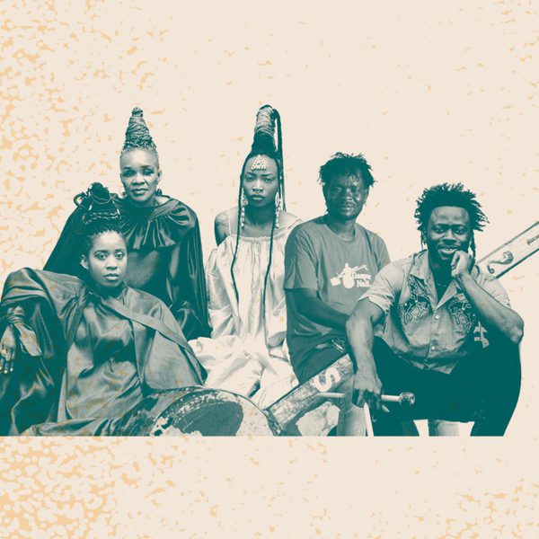 black and white image of members of L’Amazones d’Afrique and Gaspar Nali looking at the camera with a cream background