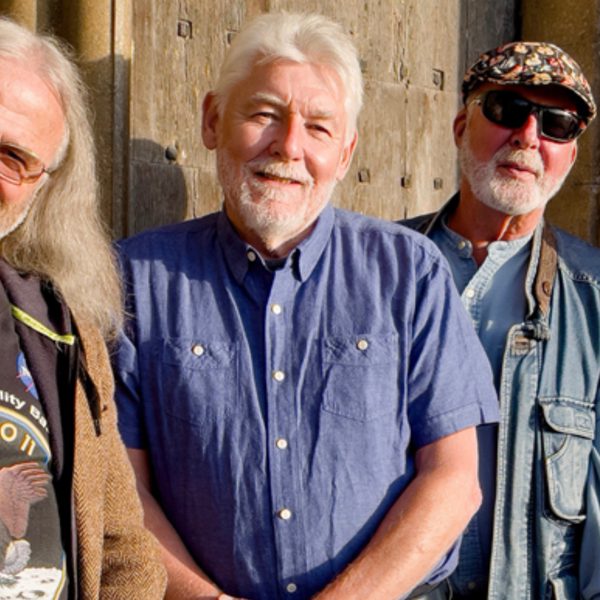 Members of Fairport Convention standing in a row smiling at the camera