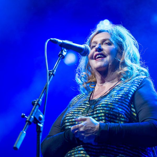 Mary Coughlan singing into a microphone with blue hue lighting
