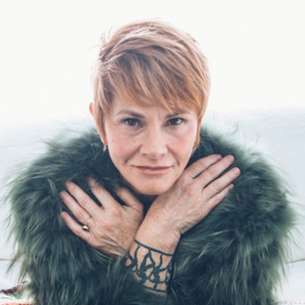 Shawn Colvin looking at the camera wearing a dark fur coat with her hands crossed over her chest