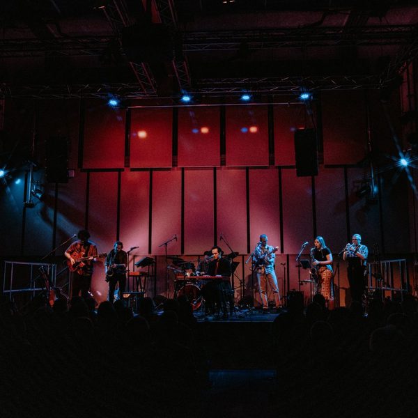 Members of Reelin' in the Dan performing on the Music Room stage in red dim lighting