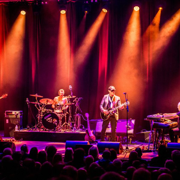 Jan Akkerman and band performing onstage, with orange lighting