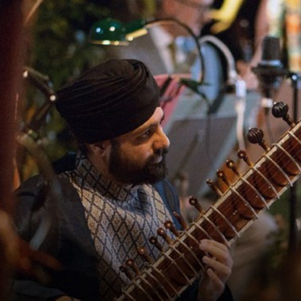 Jasdeep Singh Degun, an Indian man with a black beard, wearing a black turban and playing the sitar