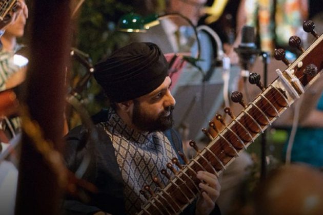 Jasdeep Singh Degun, an Indian man with a black beard, wearing a black turban and playing the sitar