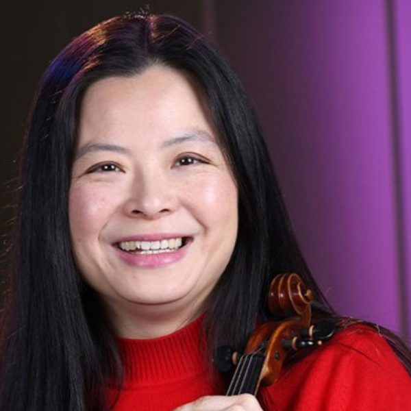 Qian Wu, an Asian woman with long black hair, wearing a red jumper and holding her violin