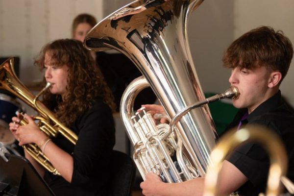 Members of Youth Brass Band wearing all black and playing their instruments