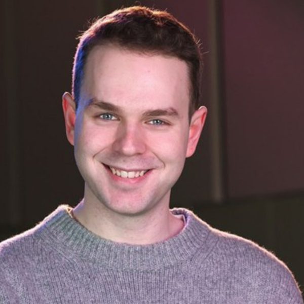 Matthew Brett, a white man with short brown hair, wearing a grey jumper and smiling at the camera