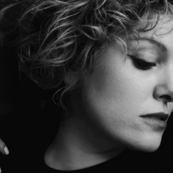 Black and white image of Jenny Daviet, who has short curly hair, looking off to the right