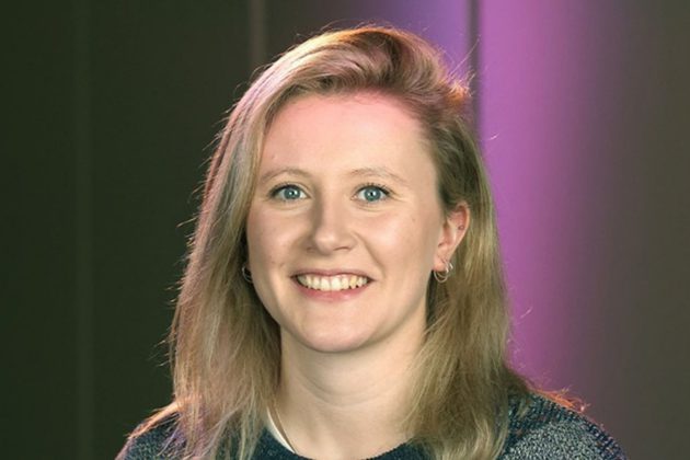 Emma Burgess, a white woman with shoulder length blonde hair, smiling at the camera