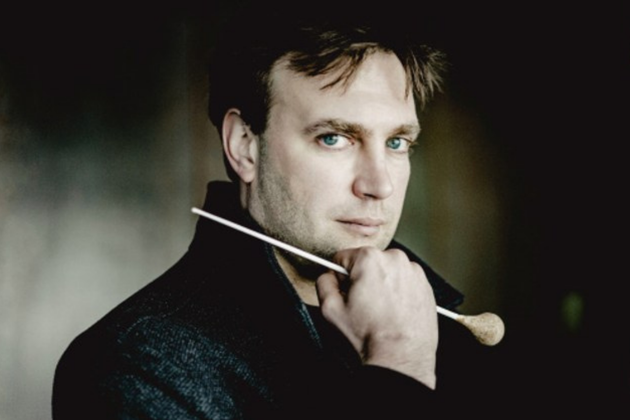 Karel Deseure, a white man with short brown hair, holding a baton and leaning on his hand