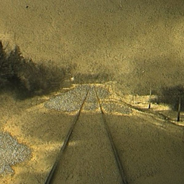 A painting of an empty railway track surrounded by trees and a yellow grey sky