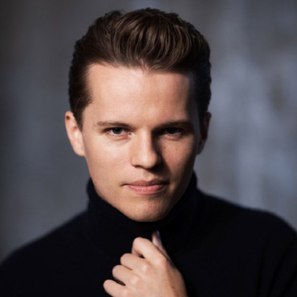 Adam Hickox, a white man with short brown hair, wearing a black turtleneck and looking at the camera