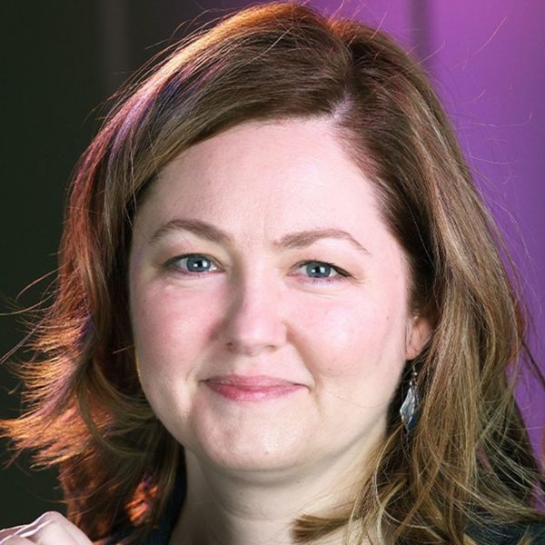 Rebekah Abramski, a white woman with shoulder length brown hair, smiling at the camera
