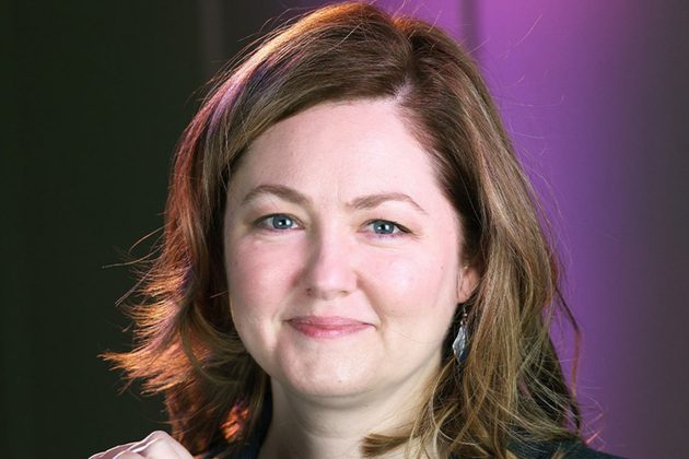 Rebekah Abramski, a white woman with shoulder length brown hair, smiling at the camera